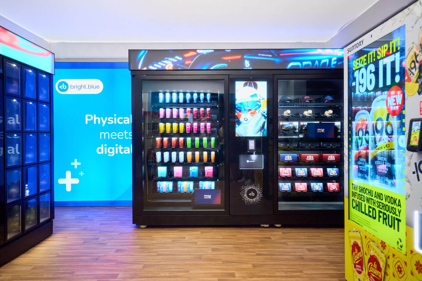 Bright.Blue retail media machine with a digital screen, branded products and chilled drinks at the front.